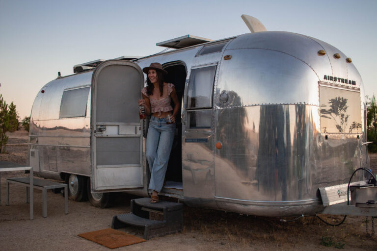 woman exiting a vintage trailer stay at Vinyl Vineyards